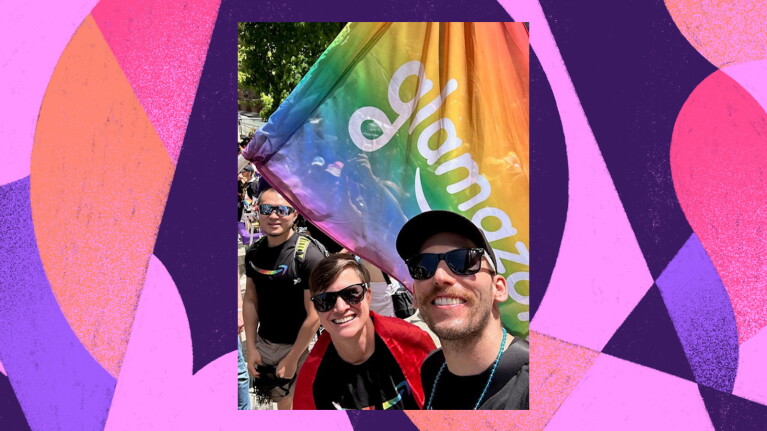 A selfie of three amazon employees waving the Glamazon flag and a colorful illustration as the background.