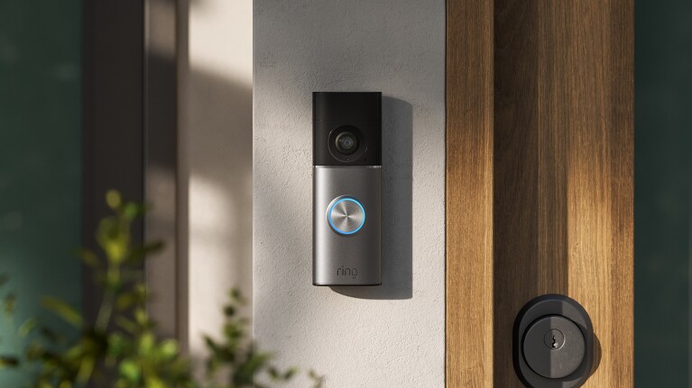 Ring video doorbell mounted next to wooden door frame