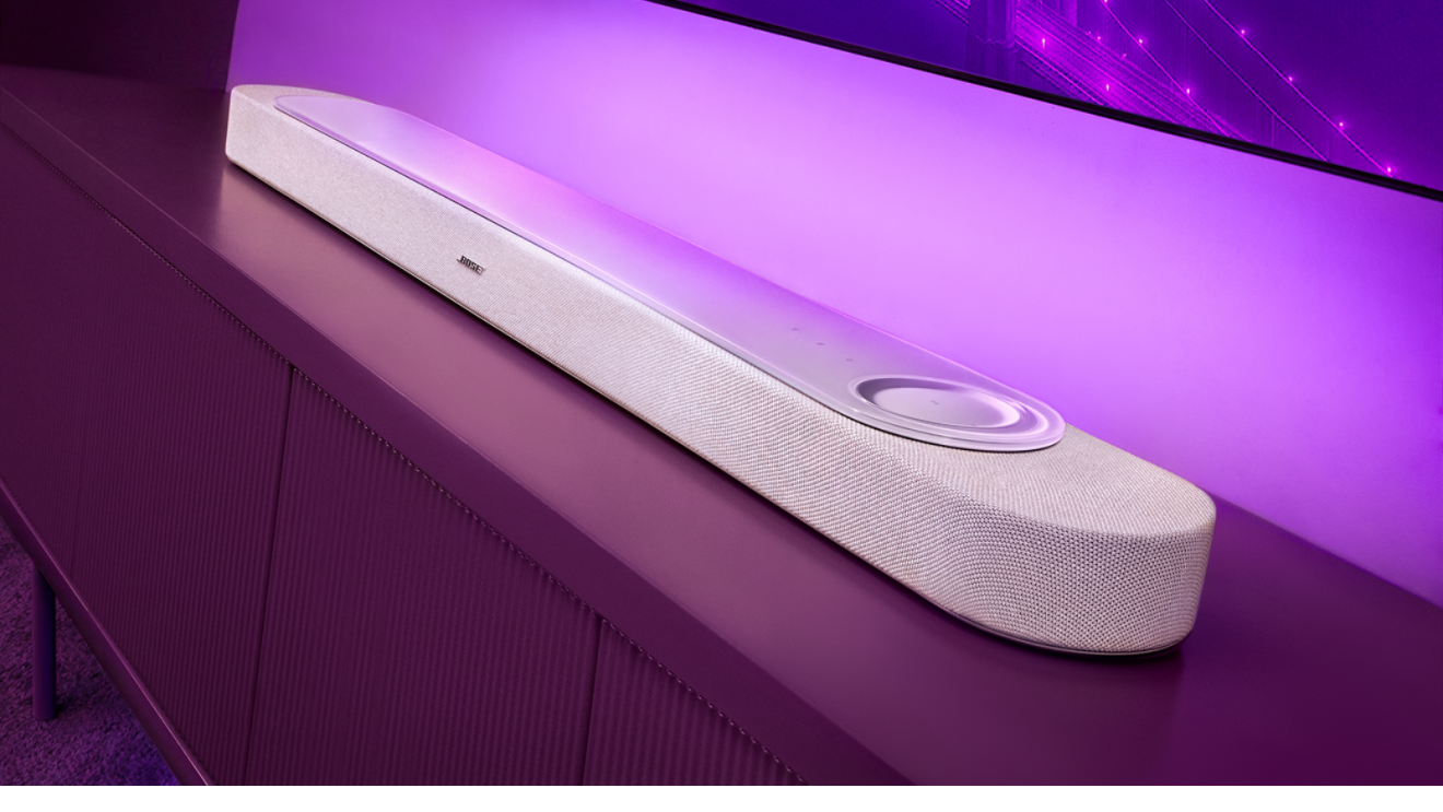 White soundbar positioned below wall-mounted television on modern entertainment console