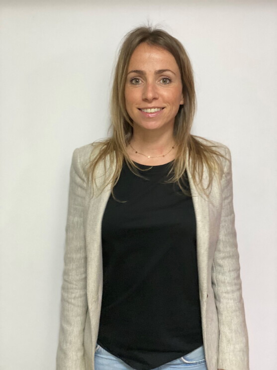 Ana Cruz Dorado, responsable de Recursos Humanos en SVQ1 (centro logístico de Amazon Robotics en Sevilla). Con una jersey negro y una americana gris. Se aprecian unos jeans. El pelo rubio por el hombro y los ojos verdes. Lleva una cadena de oro con estrellas.  