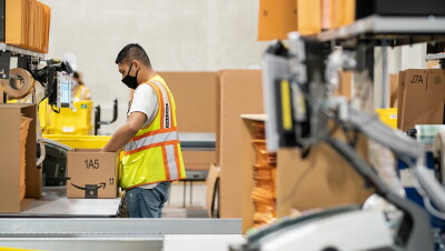 Ops employee with a face mask, packing an order in the Singapore fulfillment centre