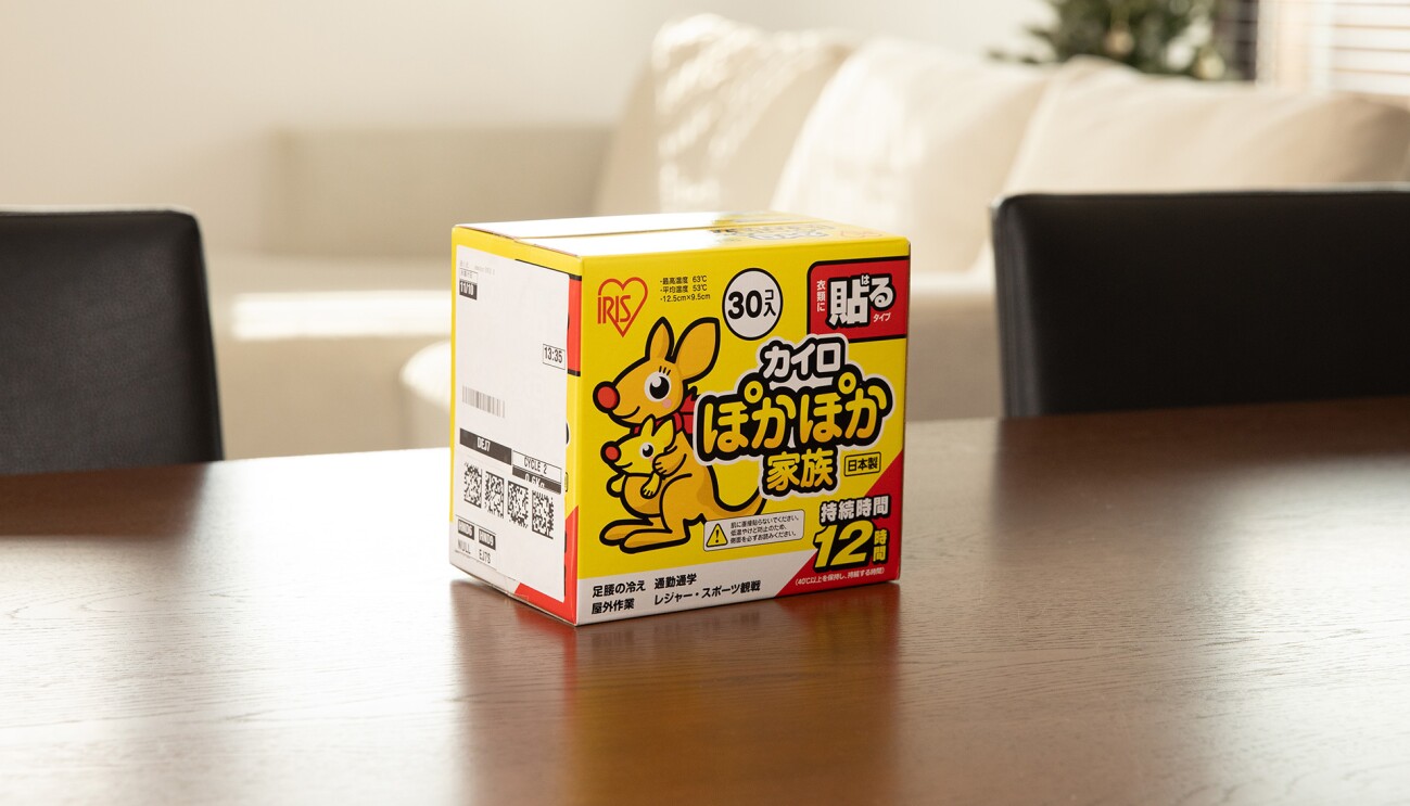 テーブルに置かれた貼るカイロの箱。側面に配送用ラベルが貼られている