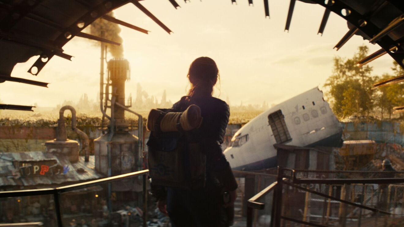Fallout: Silhouette gazes at dystopian cityscape from scrapyard platform