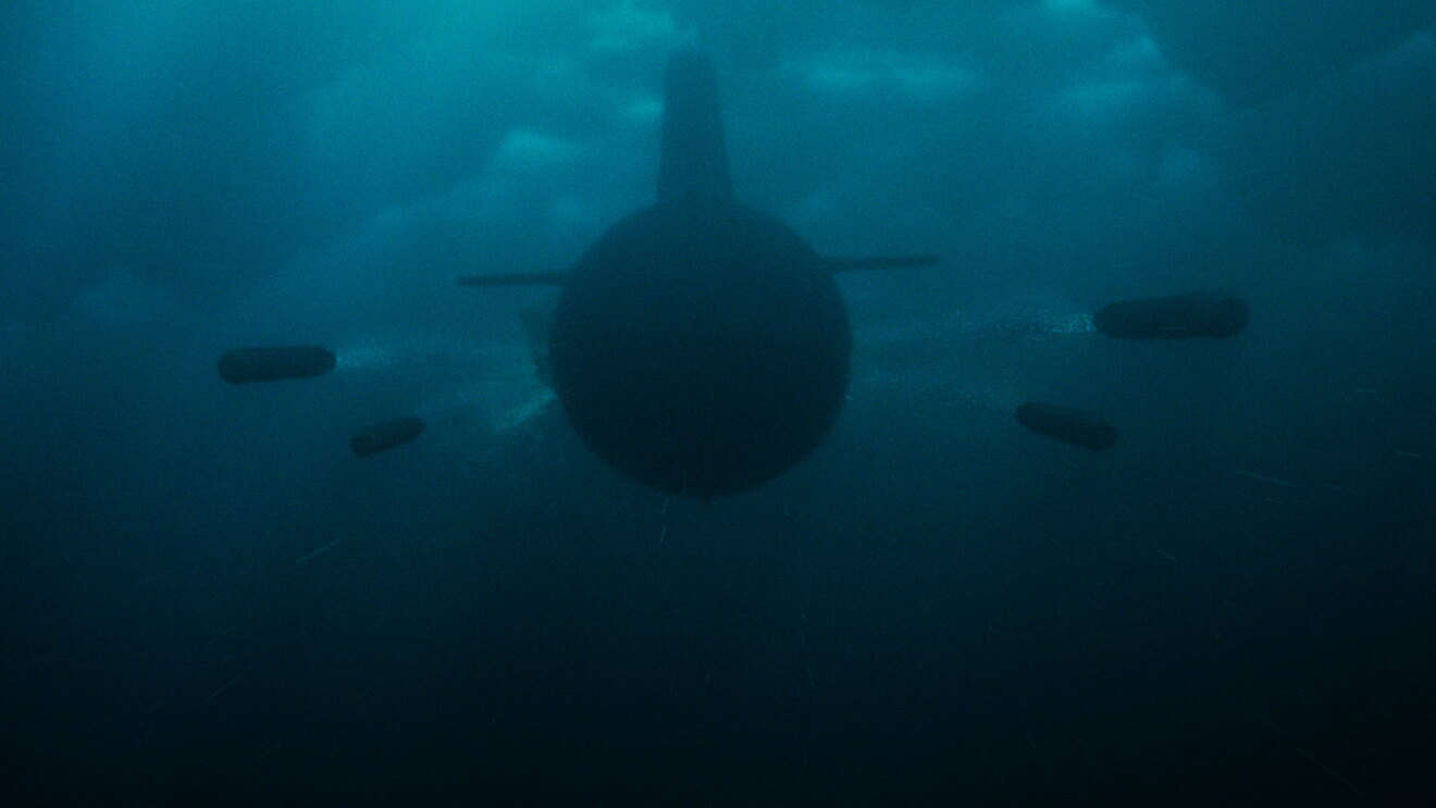 氷に覆われた海の中を、潜水艦のようなものが正面から進んでくる。潜水艦の両側に、円筒状の物体が左右2つずつ進んでいる。
