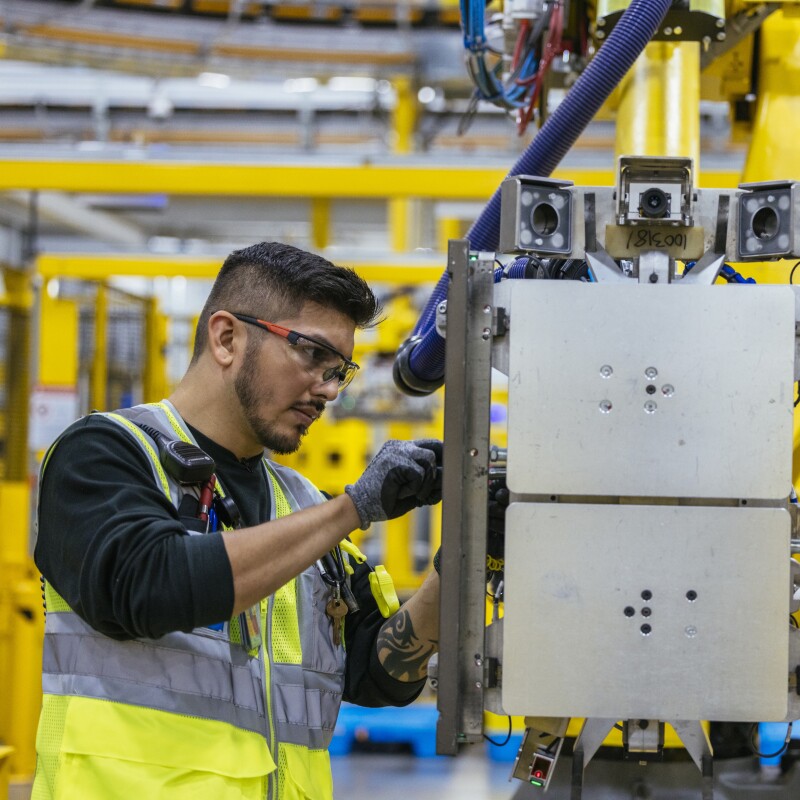 亚马逊员工在履行中心与机器人机械工作。