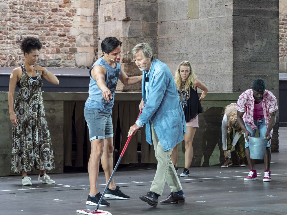 Horst Janson als Hausmeister ist auf der Bühne mit weiteren Schauspielern zu sehen