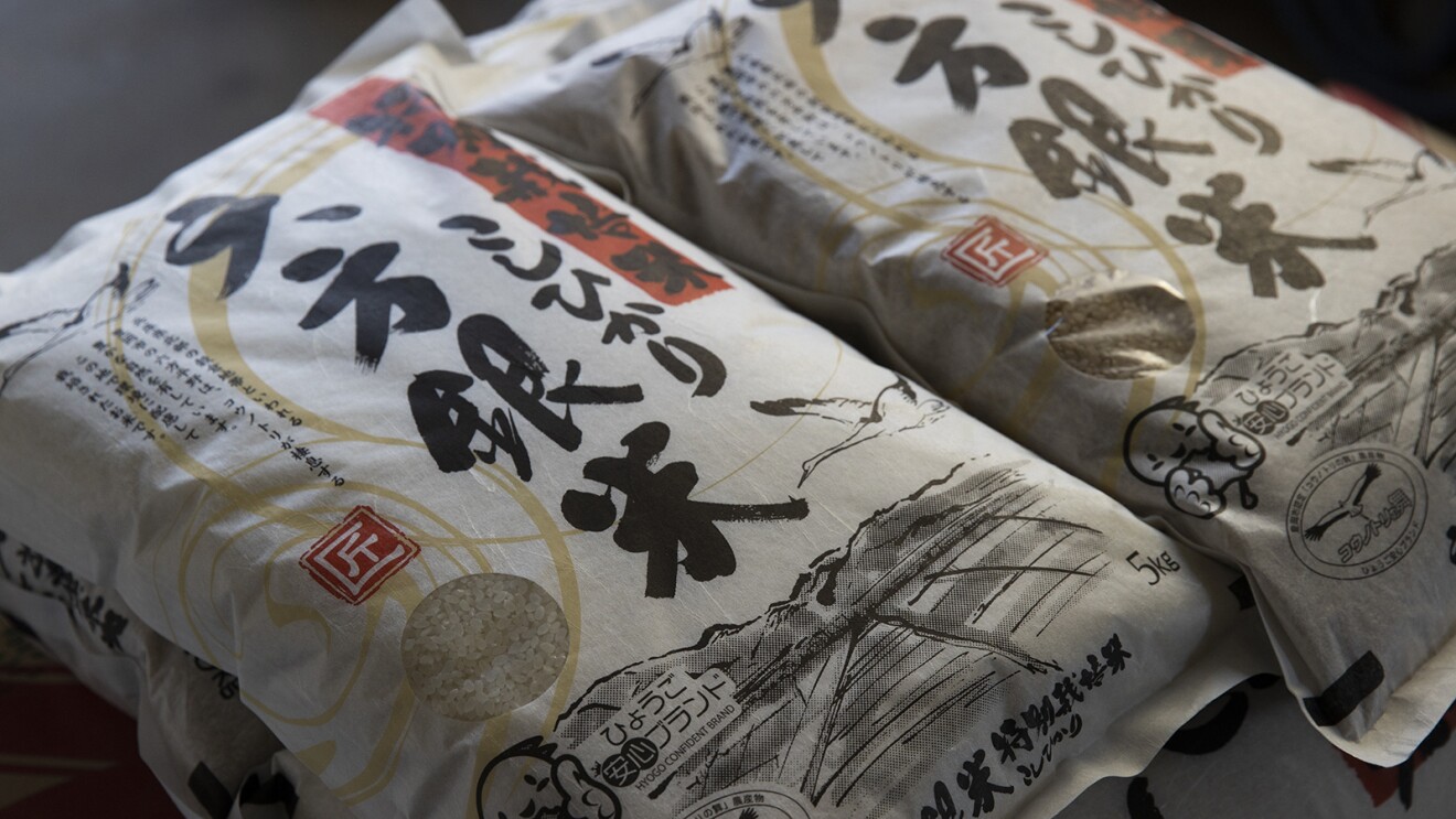 白い和紙のようなパッケージに水墨画のようなタッチで里山の風景が描かれているコシヒカリ「六方銀米」のパッケージ