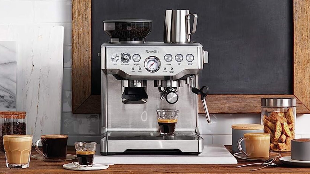 A lifestyle image of a Breville espresso machine that's set on a countertop and brewing a fresh cup of espresso.