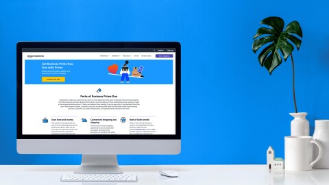 亚马逊的照片在台式电脑业务信息。旁边的电脑是一个咖啡杯和一个花瓶,一个工厂。