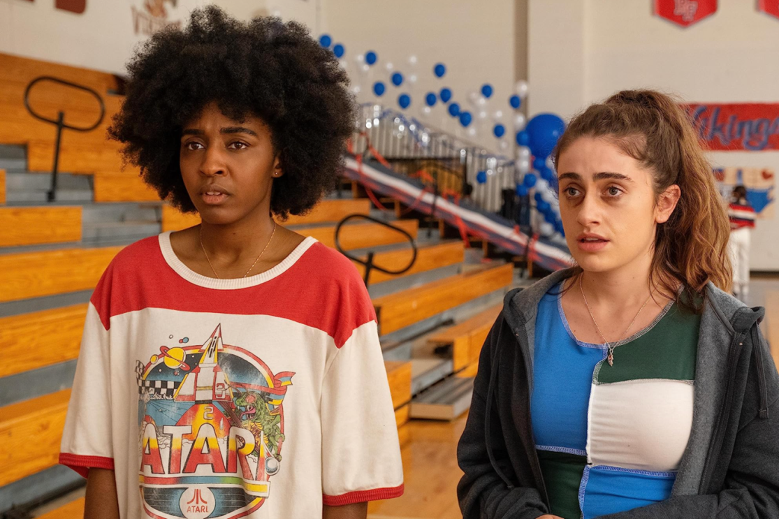 Two young girls stand in a high school gym