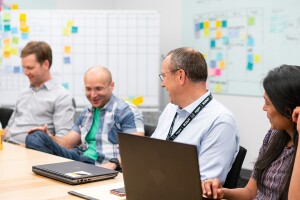 Four people sit at a table in an Amazon office, as they