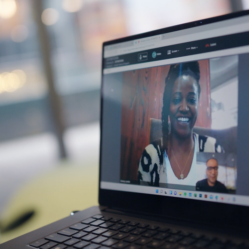 An image of a laptop showing two people having a virtual call on the screen.