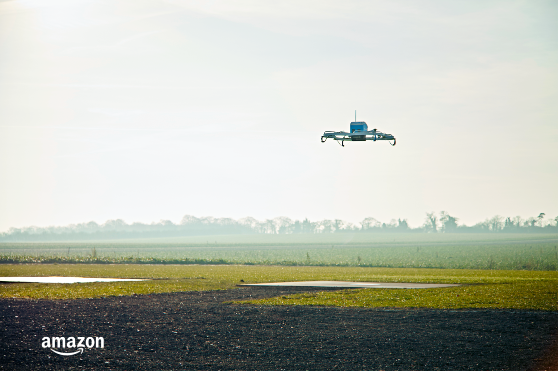 An Amazon Prime Air drone prototype flying over a field