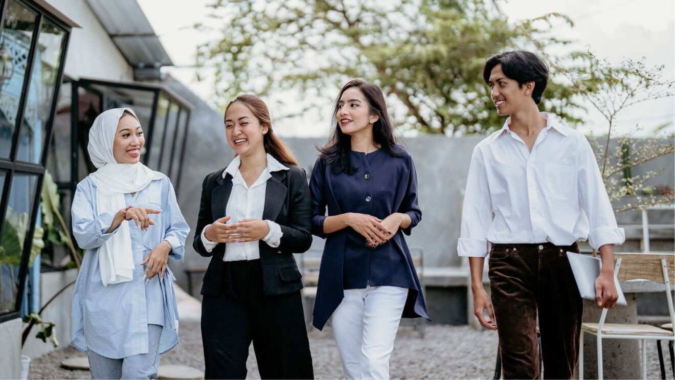 A culturally diverse group of four people walking together.