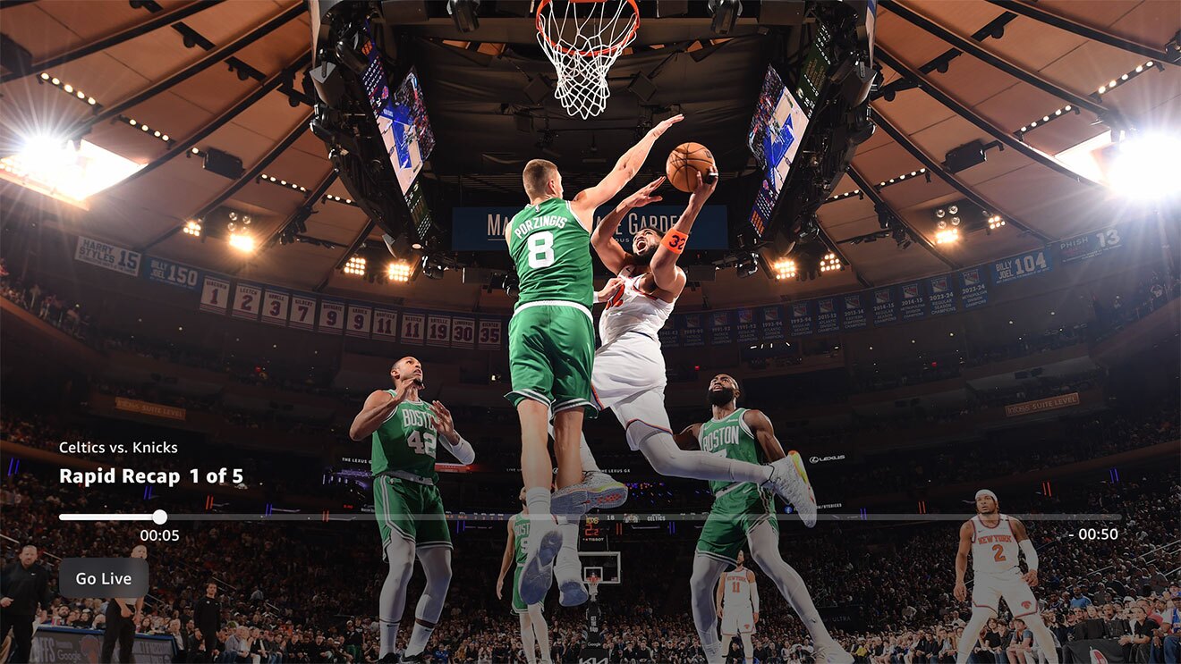 バスケットボールの試合の画面。大きなスタジアム内のゴール下で、緑のユニフォームの選手が白のユニフォームの選手のシュートをブロックしようと、両者が高くジャンプしている。画面下に動画再生バー