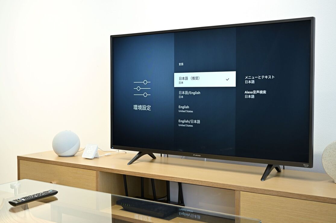 木製のテレビ台の上に置かれた黒いテレビ。その画面に環境設定という文字が書かれている。