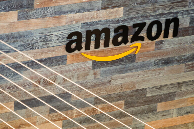 The word amazon in black lettering, with the Amazon Smile in yellow, on a wood plank wall at Amazon's Seattle HQ.