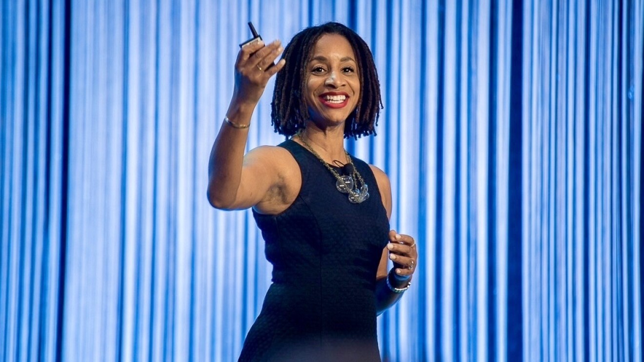 A woman smiles as she gives a presentation.