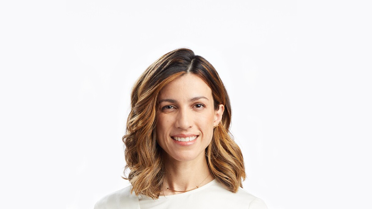 A headshot image of a woman smiling for a photo against a white background.