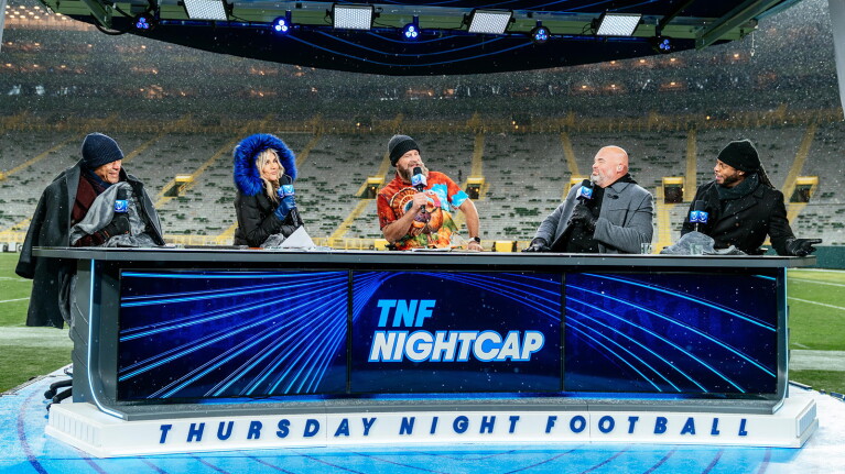 An image of the hosts of TNF Nightcap on set with the stadium behind them.