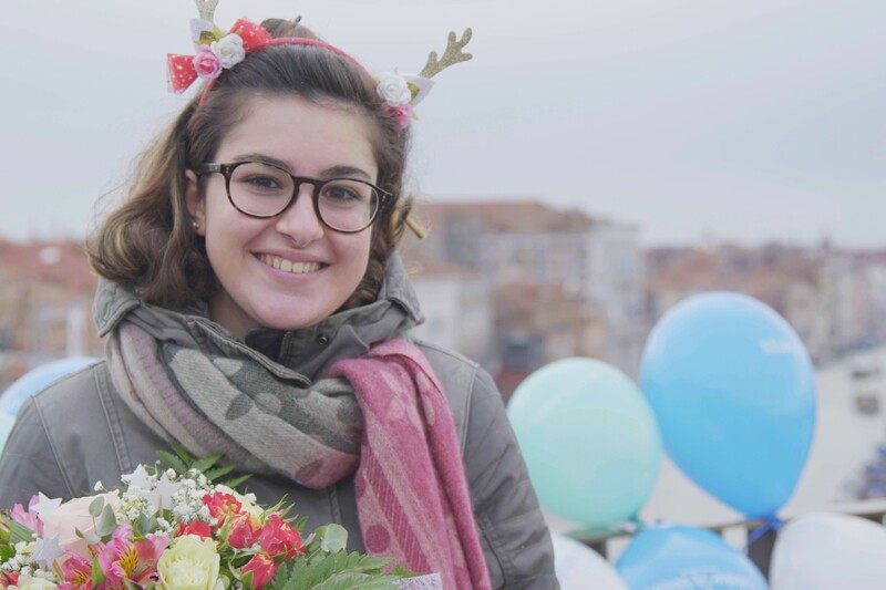 Carlotta sorridente a Venezia, con un mazzo di fiori e palloncini