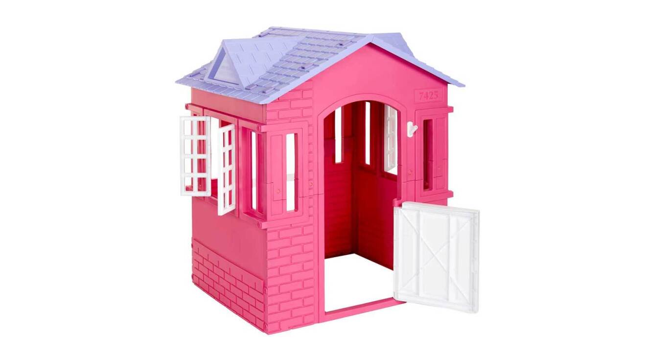 An image of a pink, life-size playhouse set for kids. It's a small, pink playhouse with a purple roof, a white door, and white window panes.