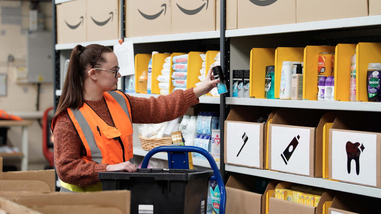 A volunteer stocks shelves at the newest Amazon Multibank in Swansea