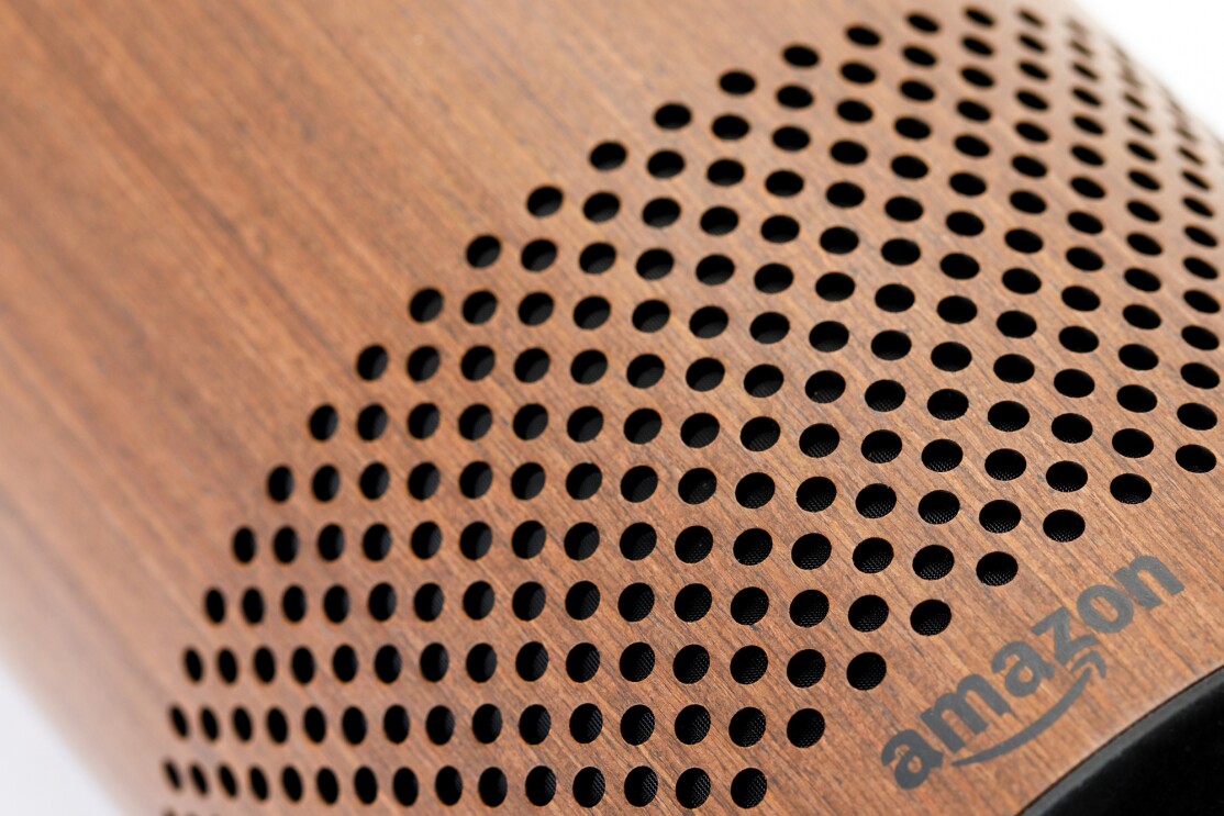 The speaker of a wood Amazon Echo tower. 