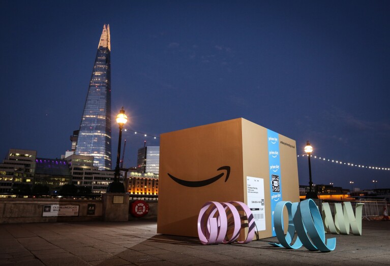 A giant Amazon box (about 8ft by 8ft) at dusk in London with the Shard in the background