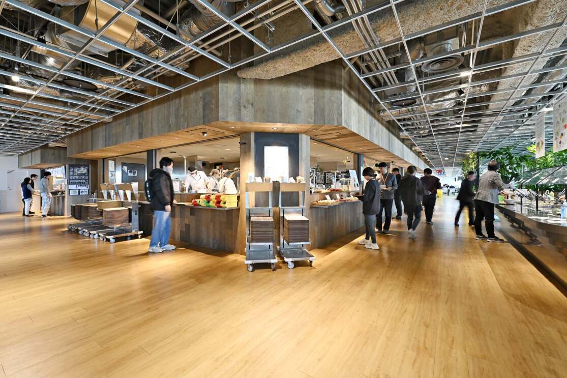 L字型の食堂のカウンターに人が並んでいる