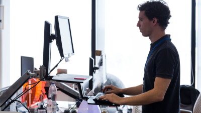 Man working on his computer at a standing desk 