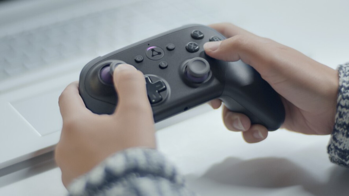 A person holds a gaming controller while playing a video game.