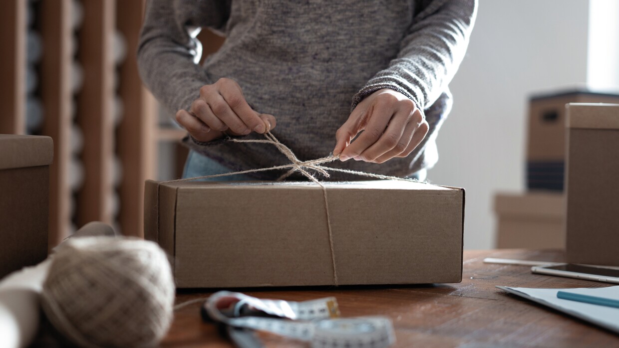 woman hands tying a parcel up with string