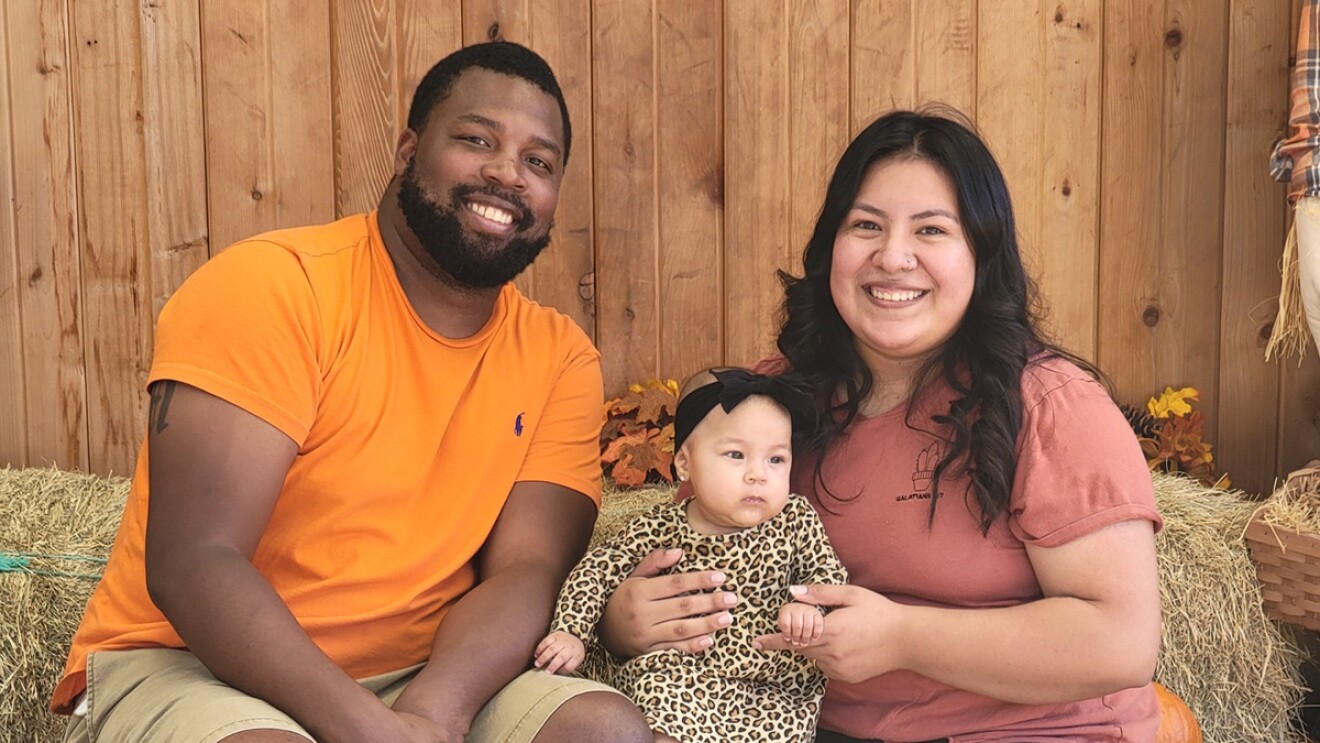 A woman who works at Amazon, poses with her family.