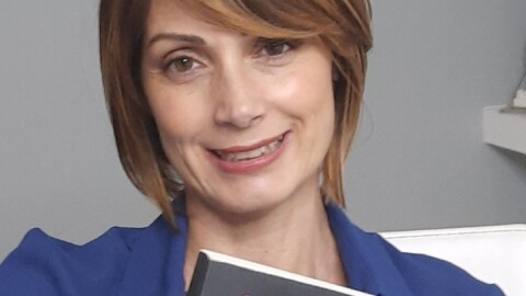 Primo piano dell'autrice Cristina Stillitano con in mano il suo romanzo 'Andrai, tornerai, non morirai'