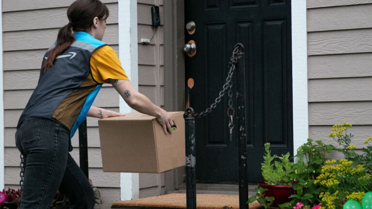An Amazon driver delivers food supplies to a home in need.