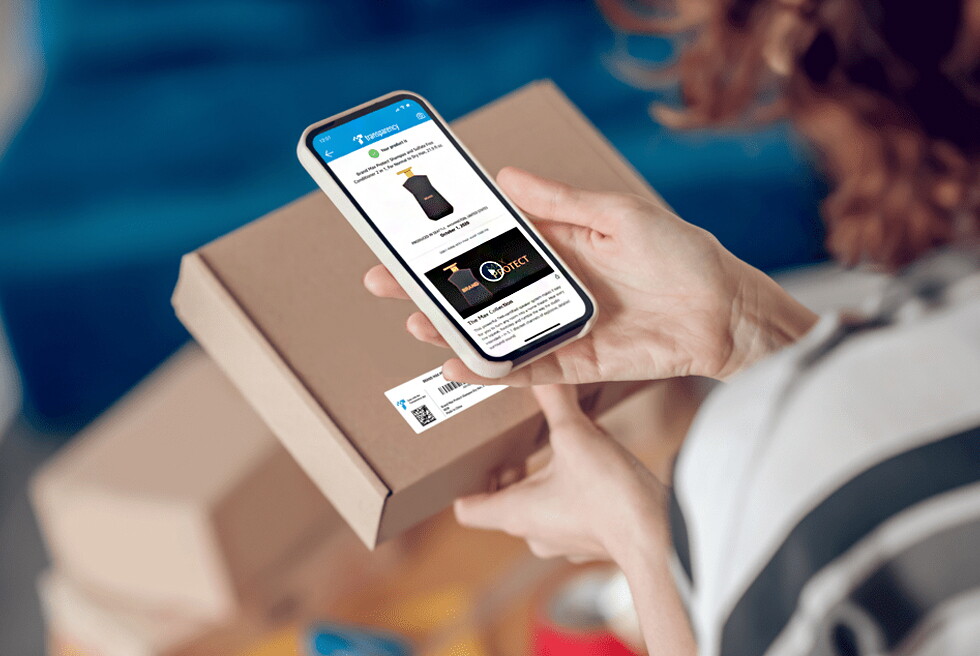 A person holds a mobile device over a package to scan a barcode and register a product