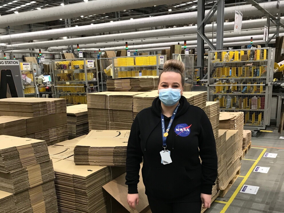 Gintare Lapinaite, FC Lead, standing in a fulfilment centre next to lots of Amazon boxes.