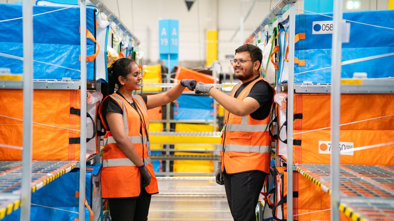 Smiling colleagues celebrating teamwork in distribution center
