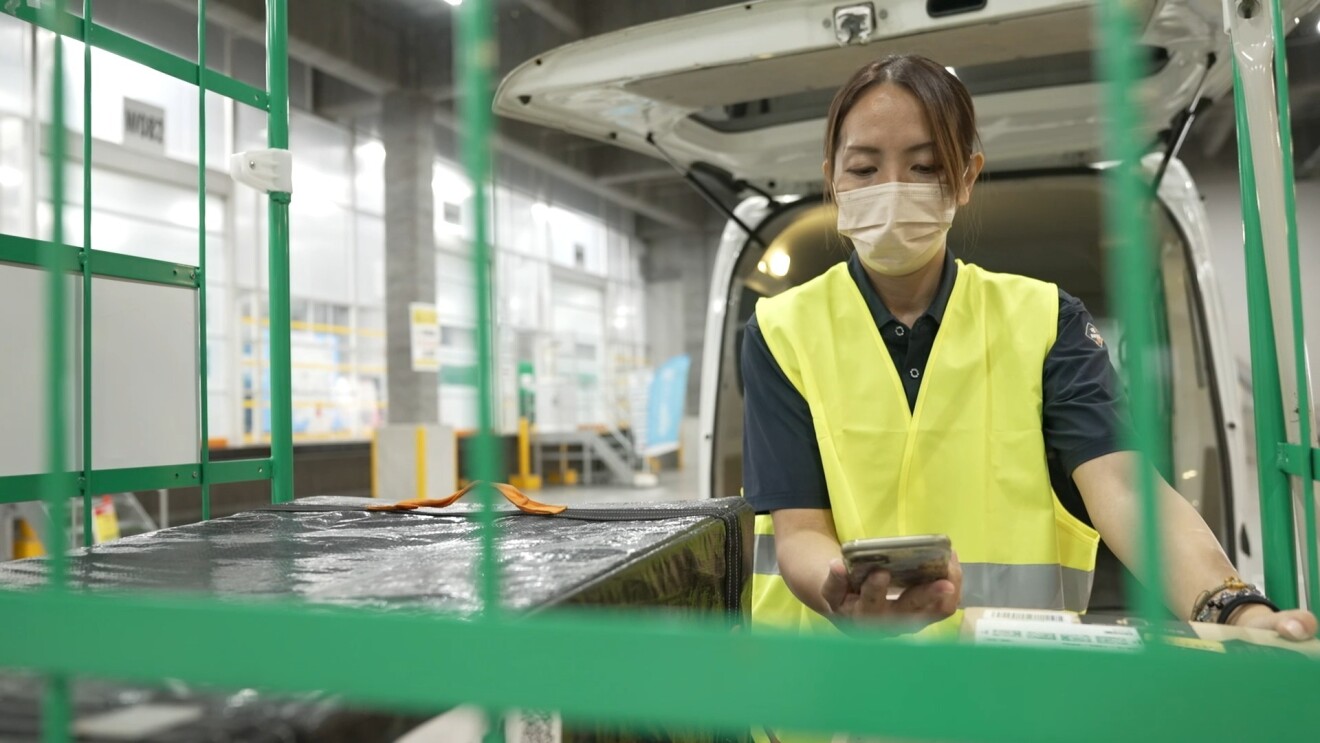 荷物を車に積む宮本さん