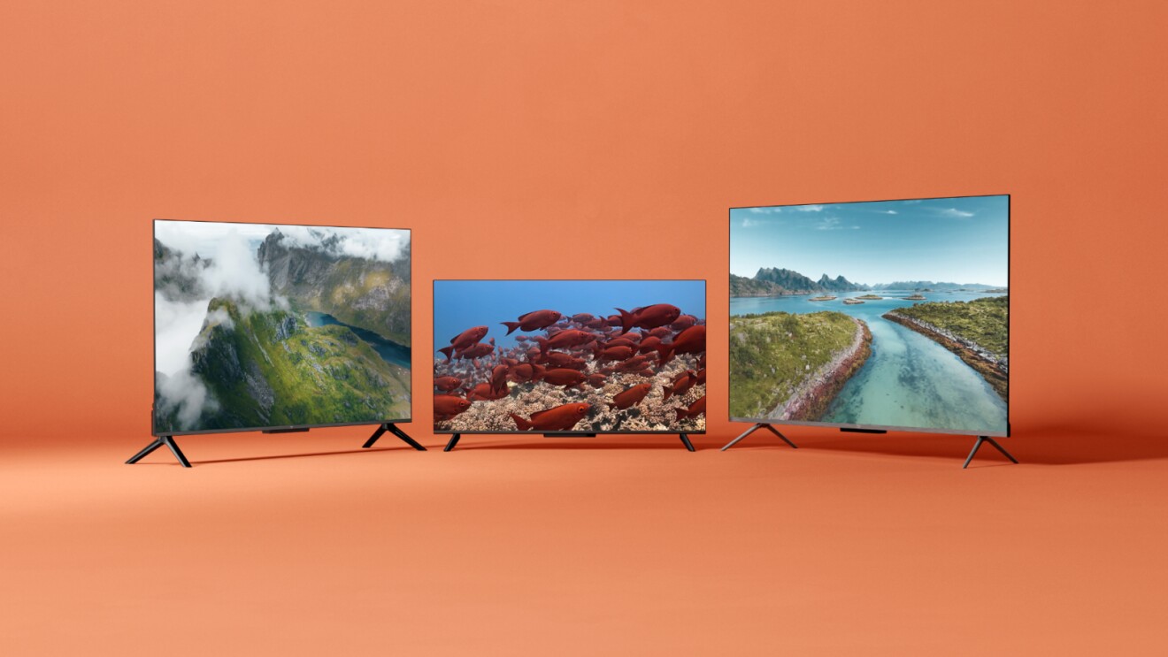 Three modern flatscreen TVs displaying nature scenes on orange background