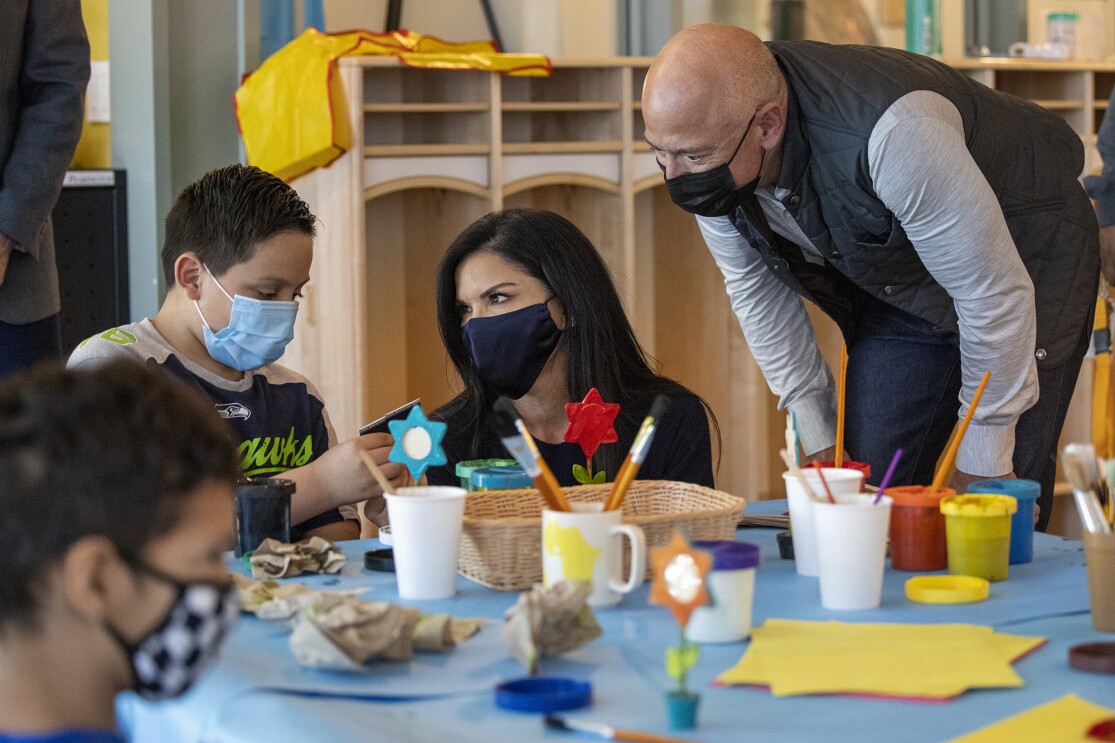 An image of Jeff Bezos and Lauren at an arts and crafts table with children staying at the Mary's Place Family Center.