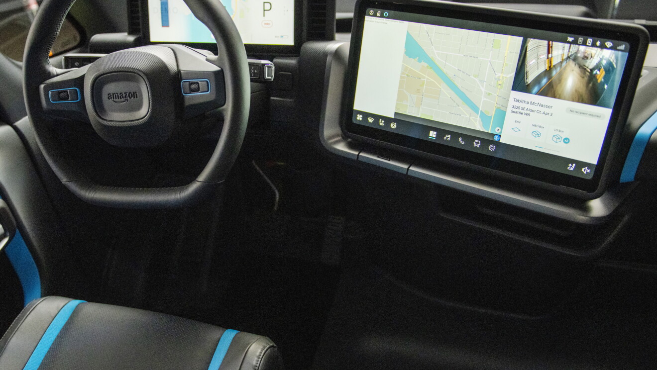 Digital displays and a steering wheel inside an Amazon electric delivery vehicle.