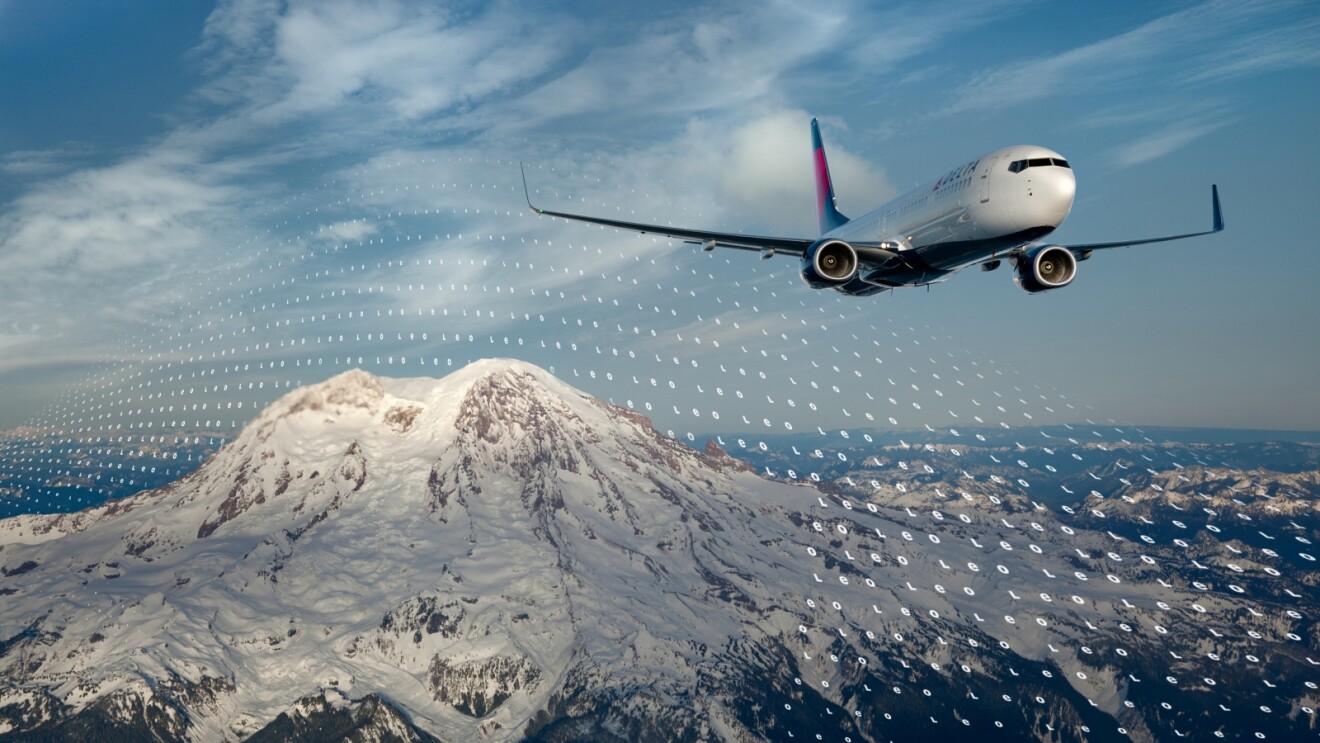 Delta Airlines plane flying over snow-capped Mount Rainier