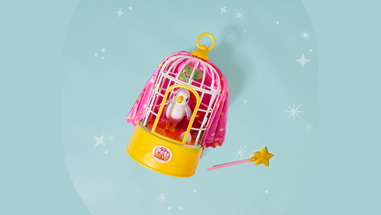 Cage à oiseaux jouet rose et jaune avec petit oiseau à l'intérieur, baguette magique à proximité