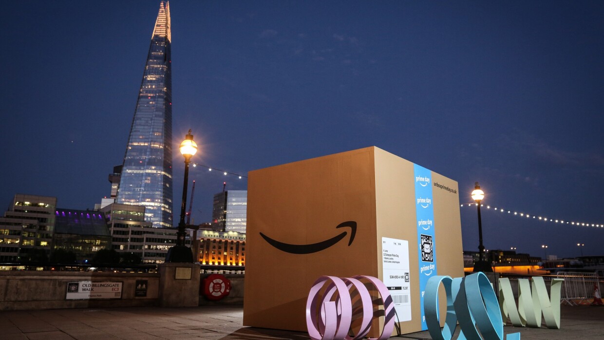 A giant Amazon box (about 8ft by 8ft) at dusk in London with the Shard in the background