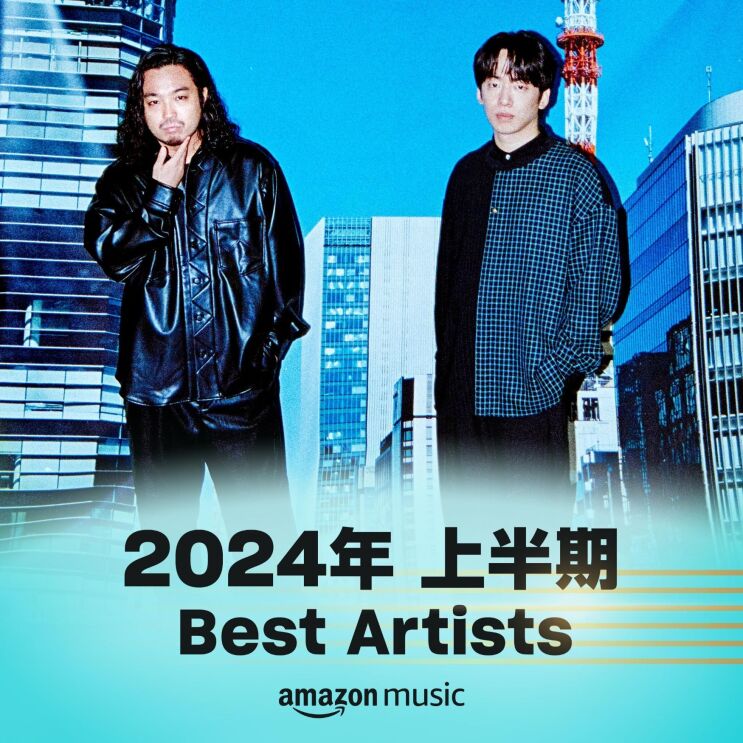 クールなポーズをしている長い髪の男性と短い髪の男性が立っている。背景は都会のビル群