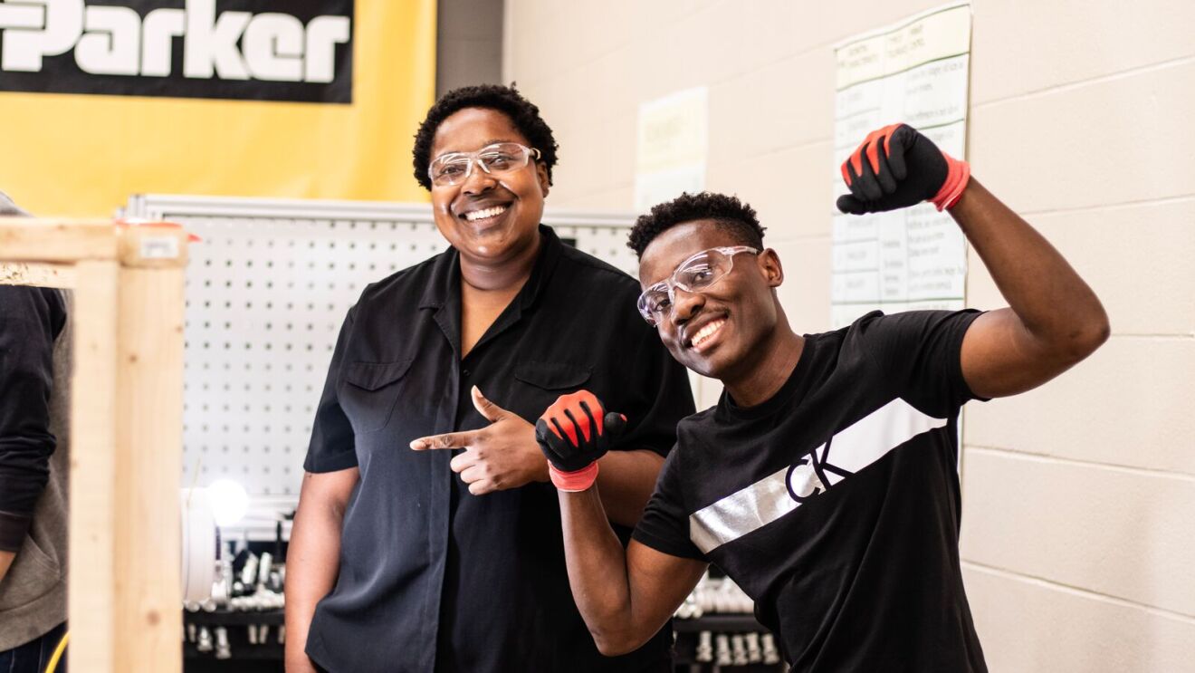 AWS training in Columbus OH: two individuals smiling and posing with safety glasses on