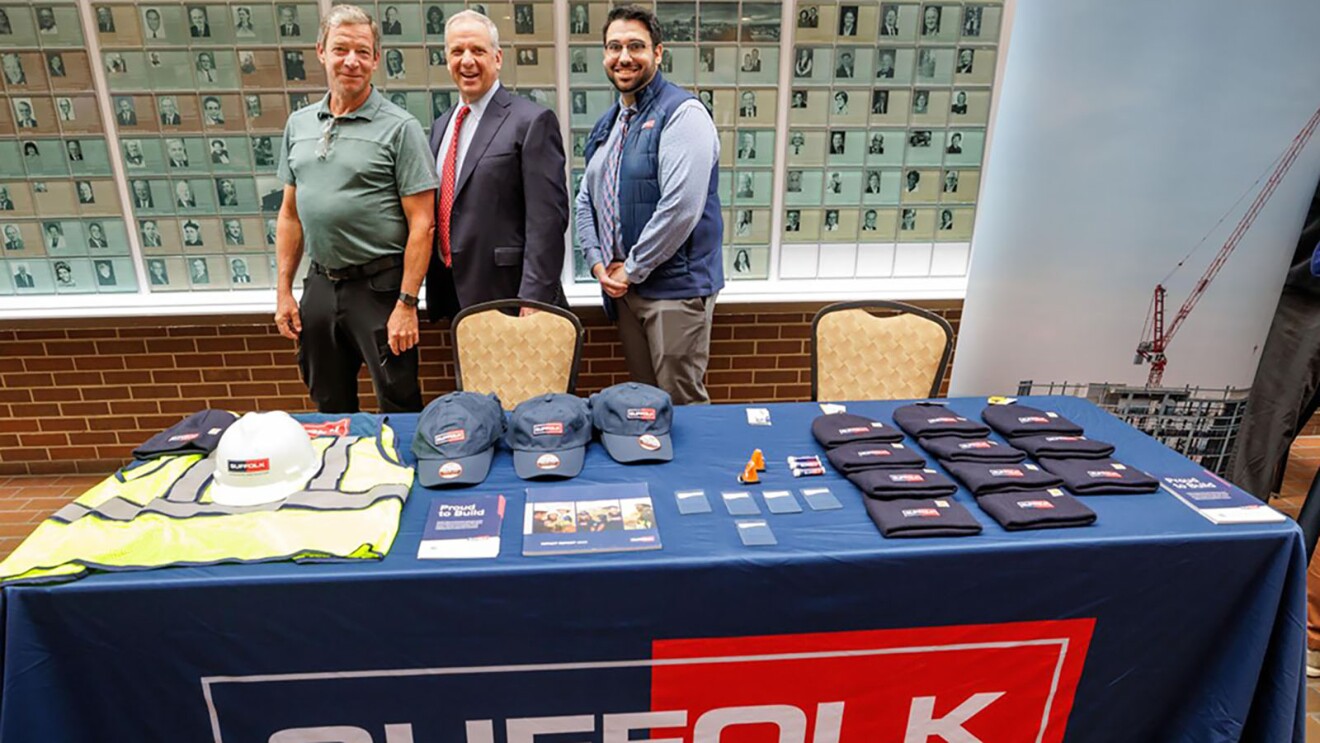 Suffolk construction company booth with promotional items and employees