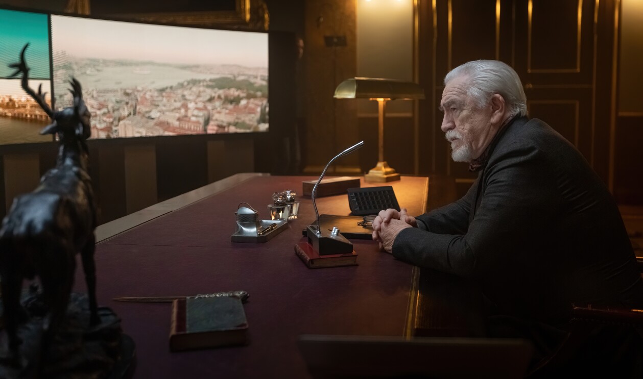 Brian Cox as The Controller sits in front of a large screen